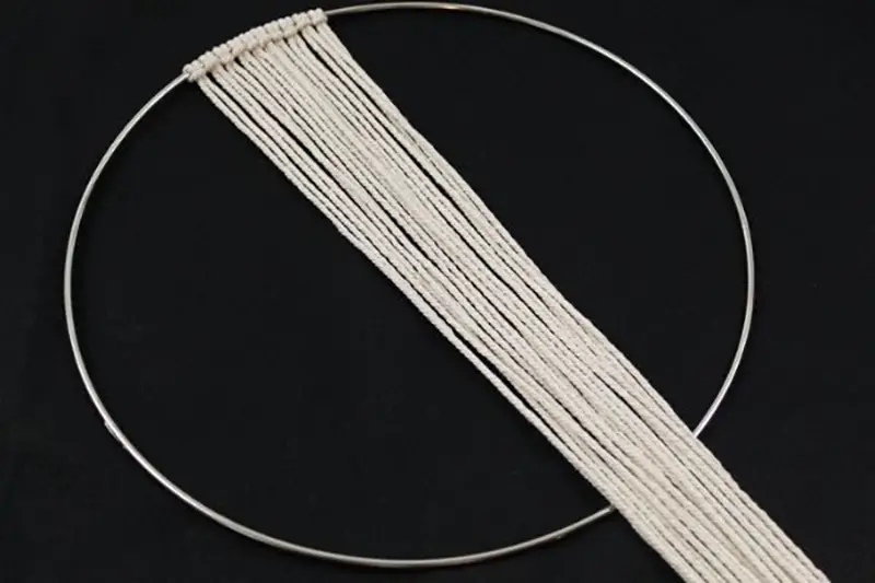 macrame string on silver hoop to start making a fall wreath with feathers