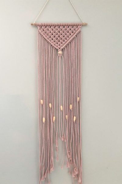 simple macrame wall hanging with beads made with dusty pink macrame string and natural colored beads
