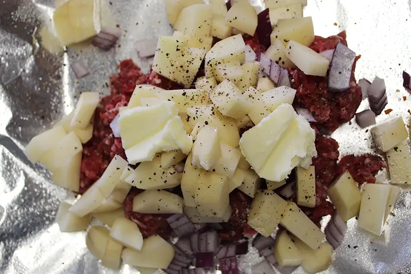 ingredients for hobo dinner placed in aluminum foil