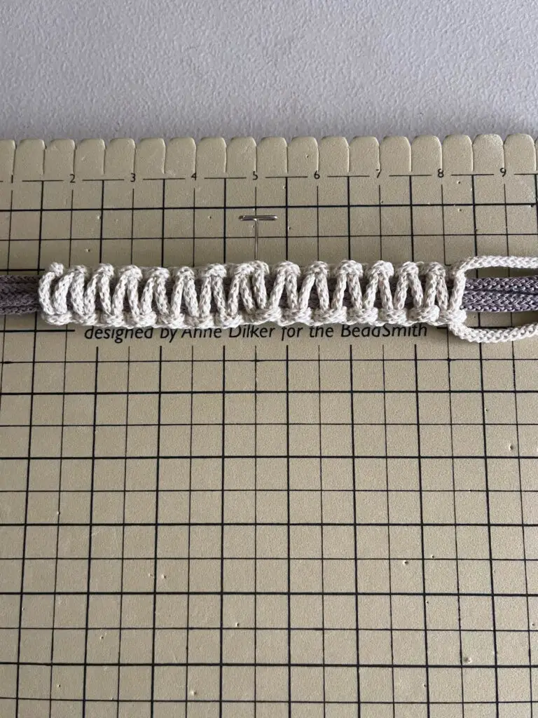 Fourteen square knots tied around plant hanger strings